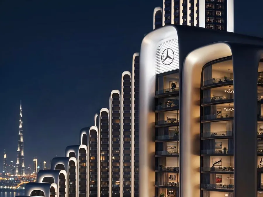 Torre residencial de luxo à noite, com o Burj Khalifa ao fundo